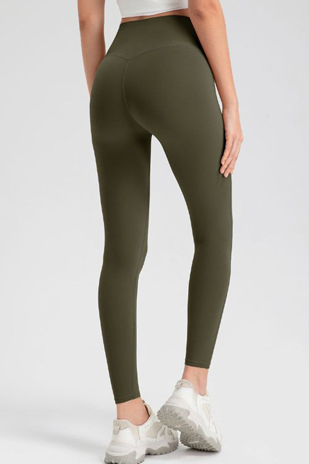 Olive green high-waist leggings with sculpting seams and a V-cut back detail.