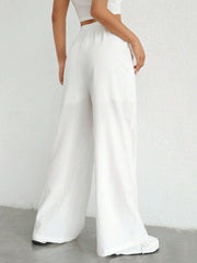 White linen wide-leg drawstring trousers with a relaxed fit.