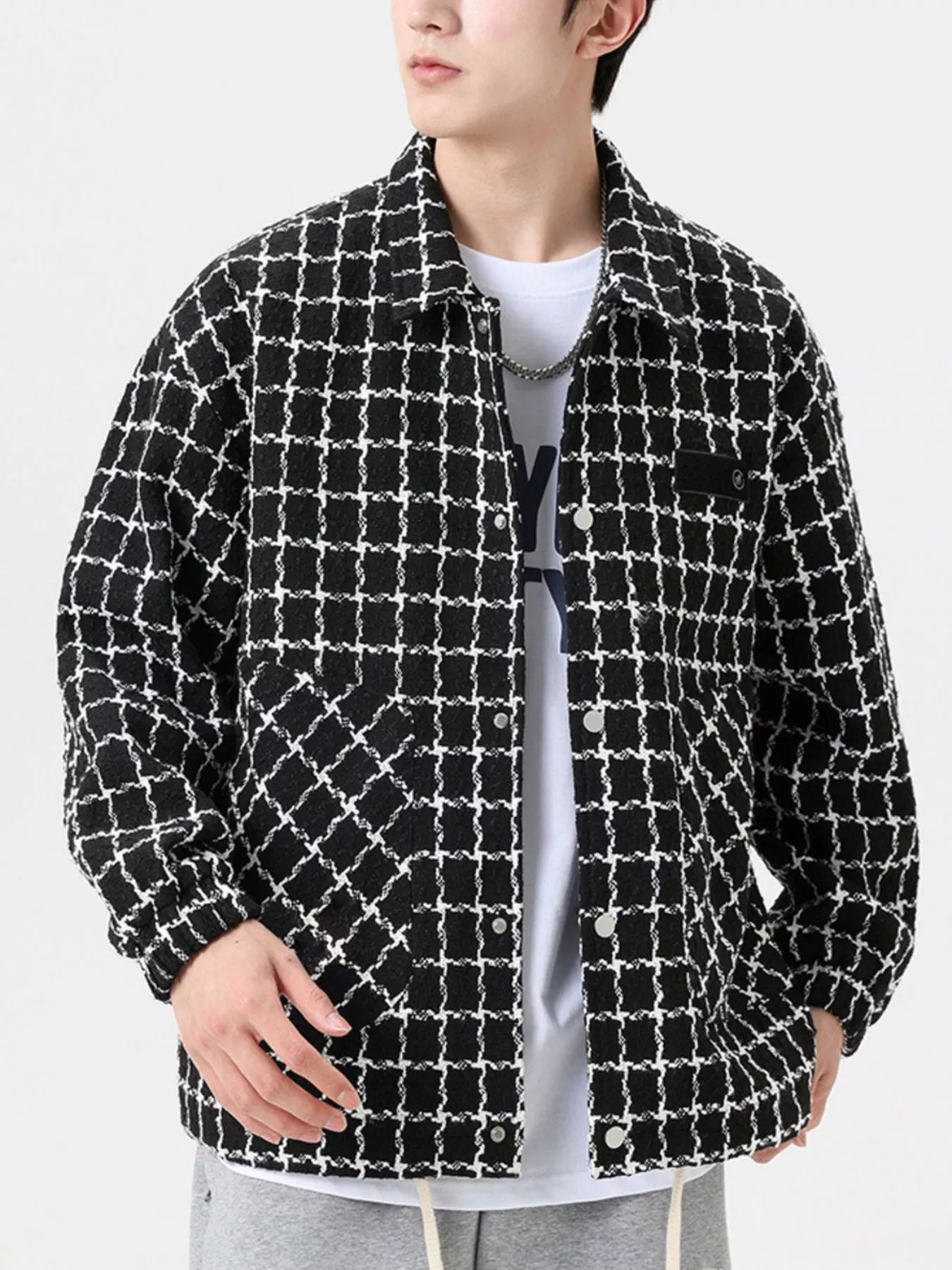 Oversized black and white plaid button-up jacket with textured fabric and chest pocket.