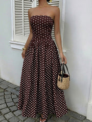 Brown polka dot A-line maxi dress with strapless neckline and cinched waist.