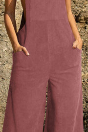 Dusty pink corduroy overalls with wide legs and front pockets.
