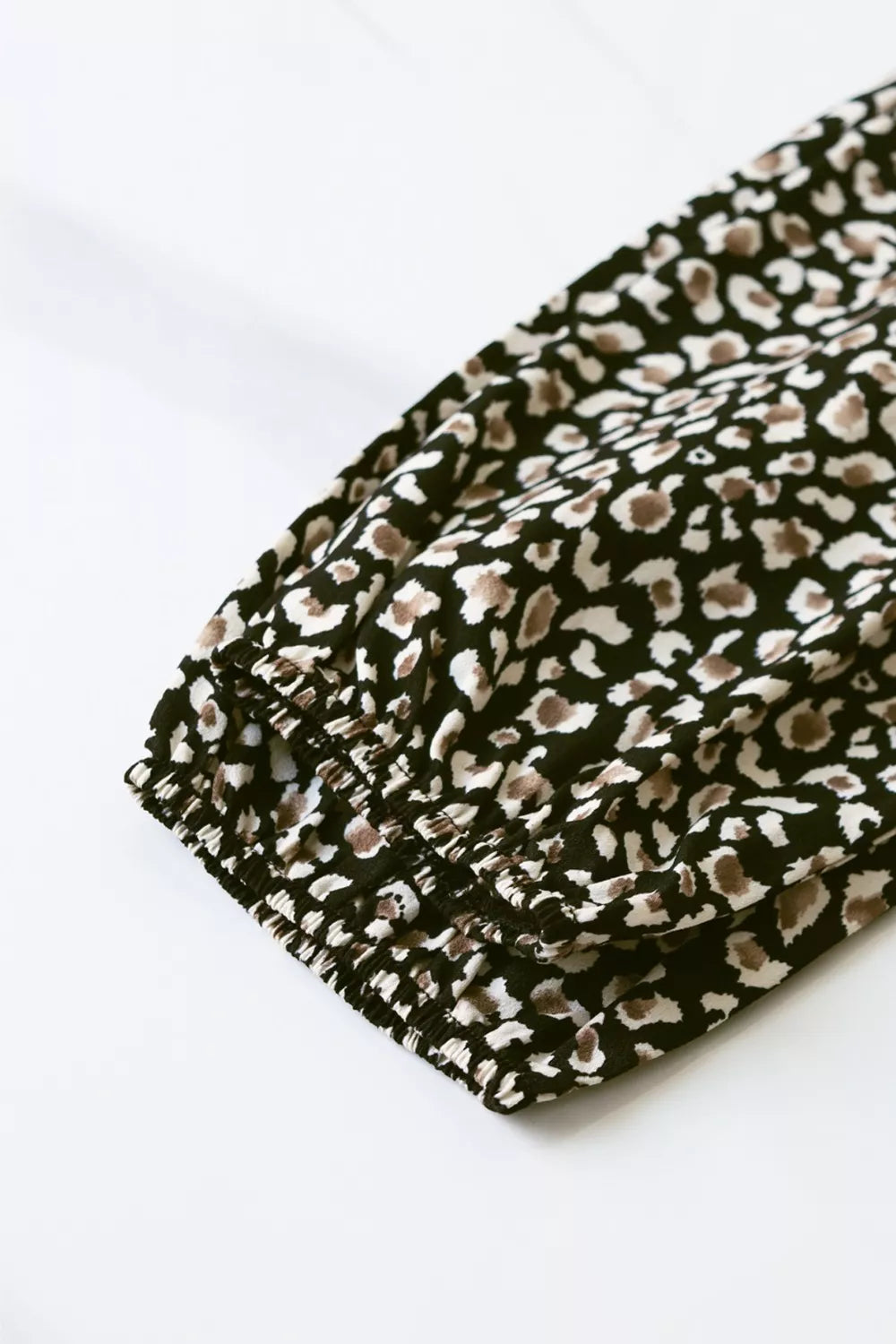 Chic midi dress with balloon sleeves in black animal print, featuring elasticated cuffs.