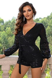 Black sequin romper with V-neck, long balloon sleeves, and tie waist.