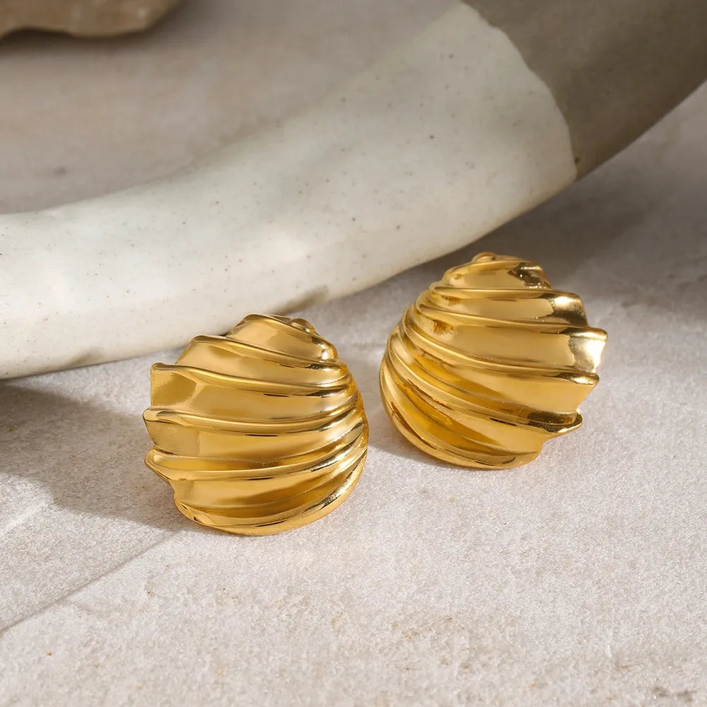 Sculpted spiral gold stud earrings with a textured, ribbed design.