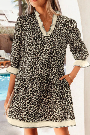 Leopard print mini dress with ruffle neckline and striped trim cuffs and hem