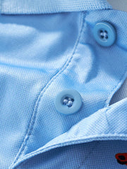 Light blue toddler polo shirt with dinosaur print detail and two buttons.