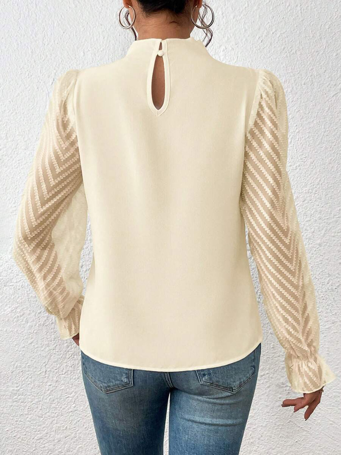 Cream ruffle neck blouse with chevron sheer sleeves and keyhole back detail.