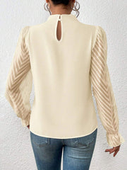 Cream ruffle neck blouse with chevron sheer sleeves and keyhole back detail.