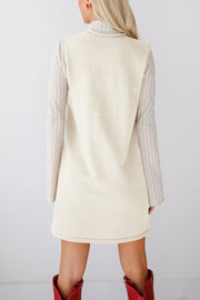 Cream knit sleeveless V-neck dress with ribbed long sleeve shirt underneath.