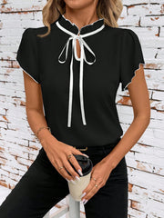 Black maternity blouse with frilled tie-neck and white trim, short sleeves.