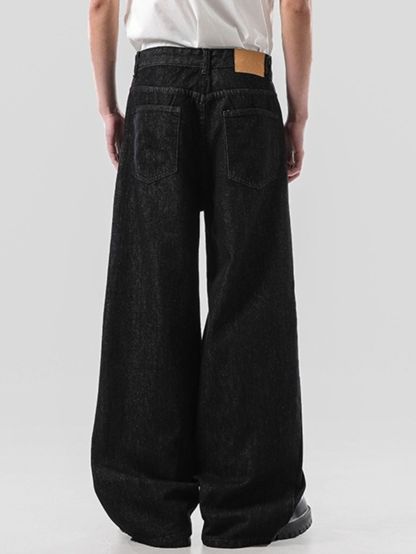 Men's dark wash wide leg jeans with a comfortable cotton fabric and a leather patch detail.