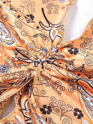 Paisley print halter top in tangerine with ruched detail and gold trim.