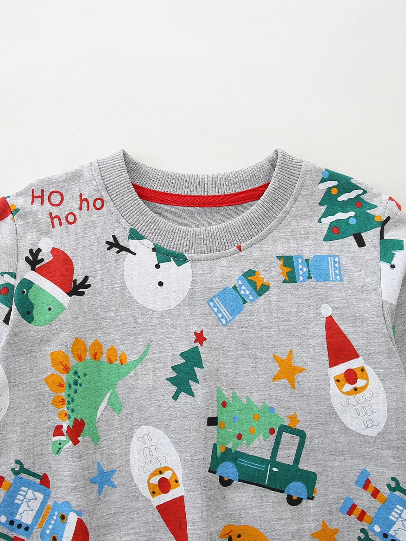 Children's gray cotton Christmas print pajama set with dinosaurs, snowmen, Santa, and trucks.