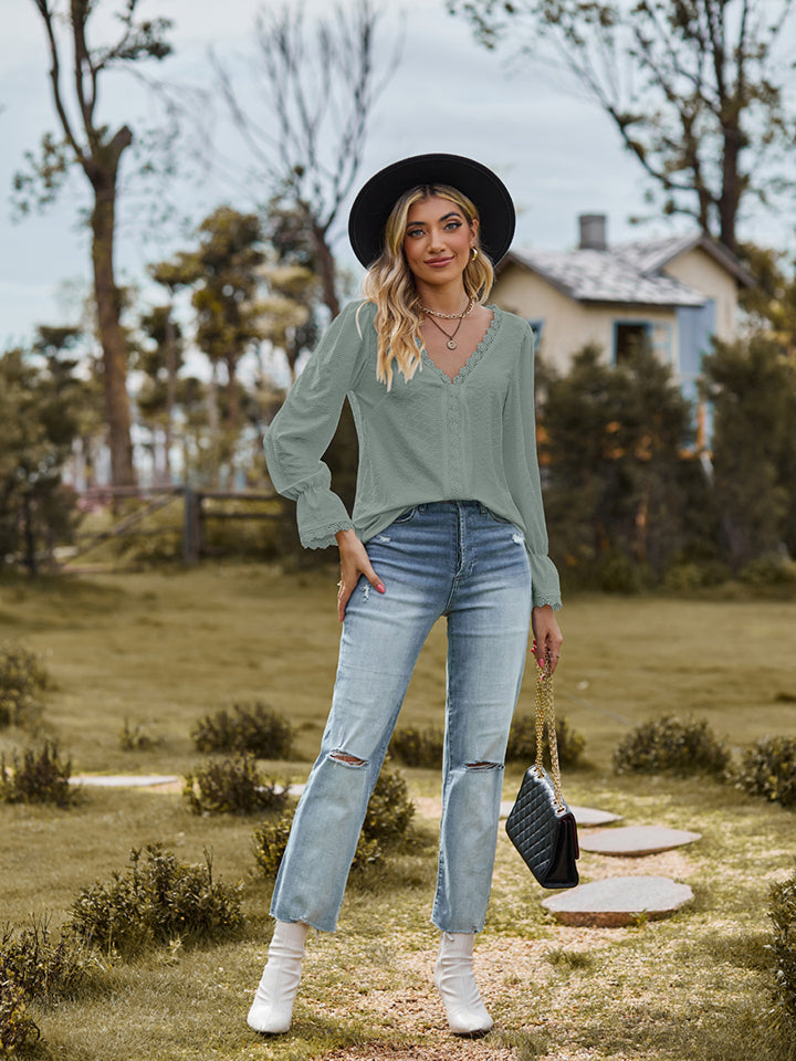 Sage green textured blouse with lace trim V-neck and long sleeves.