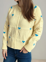 Pastel yellow zip-through knit cardigan with blue heart appliqué and ribbed cuffs.