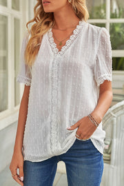 White dotted swiss blouse with lace trim and V-neck.