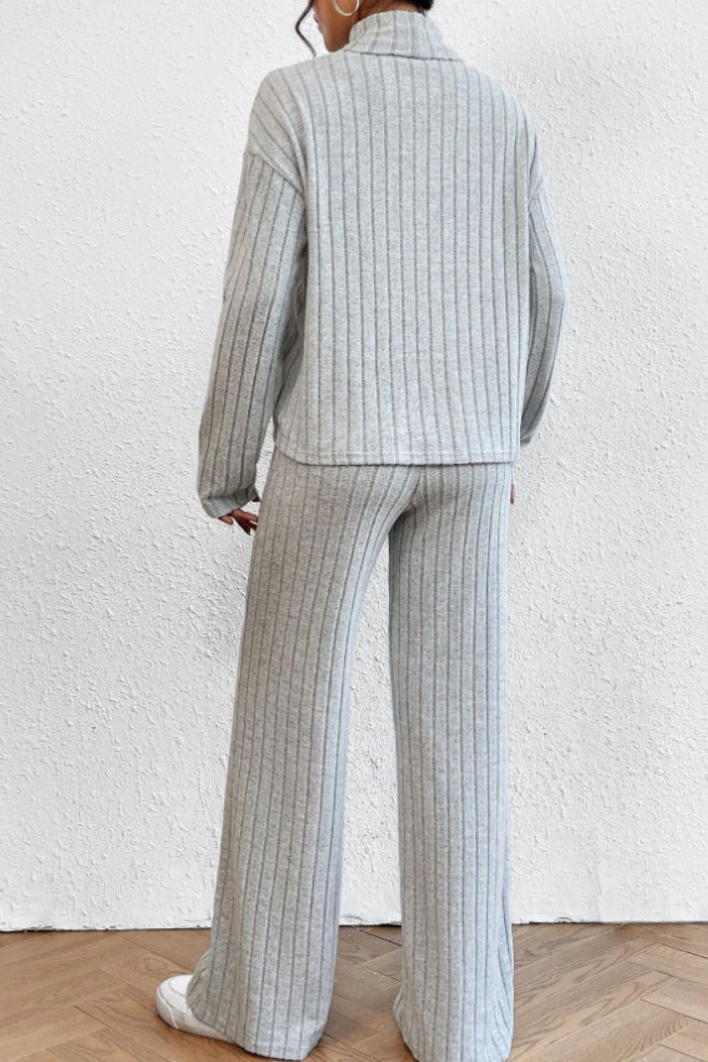 Light gray ribbed knit turtleneck loungewear set with wide leg pants.