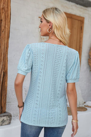 Light blue perforated puff sleeve henley blouse with eyelet details.