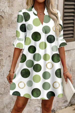 White mini dress with green polka dots and flounce sleeves.