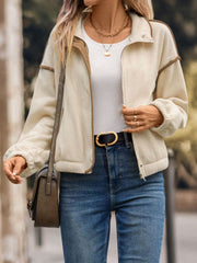 Cream fleece track jacket with contrast trim and zipper closure.