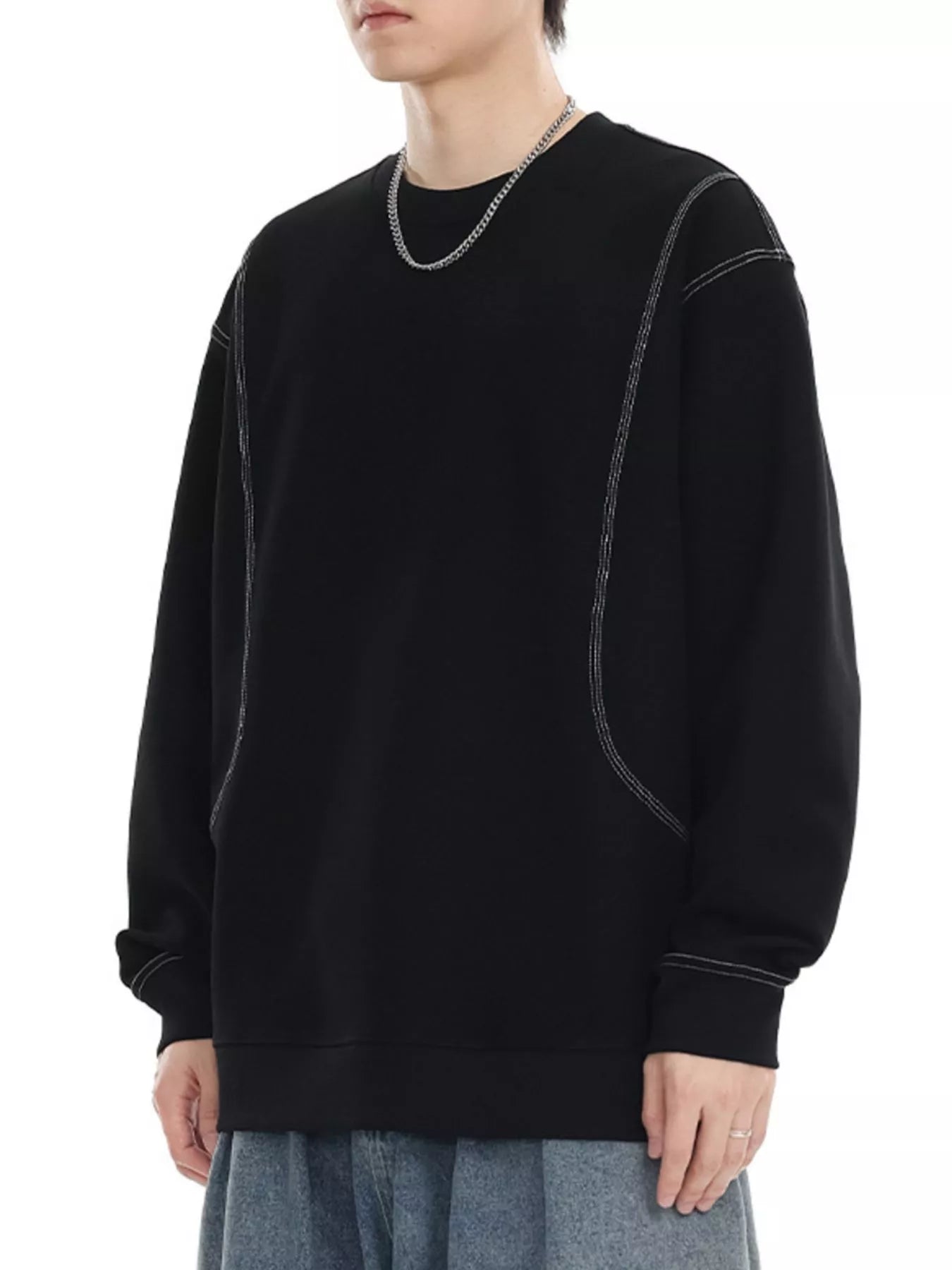 Black oversized long-sleeve sweatshirt with contrast stitching detail.