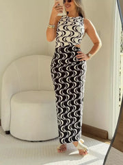 Sleek cutout maxi dress with black and white wave print, sleeveless, and high neckline.