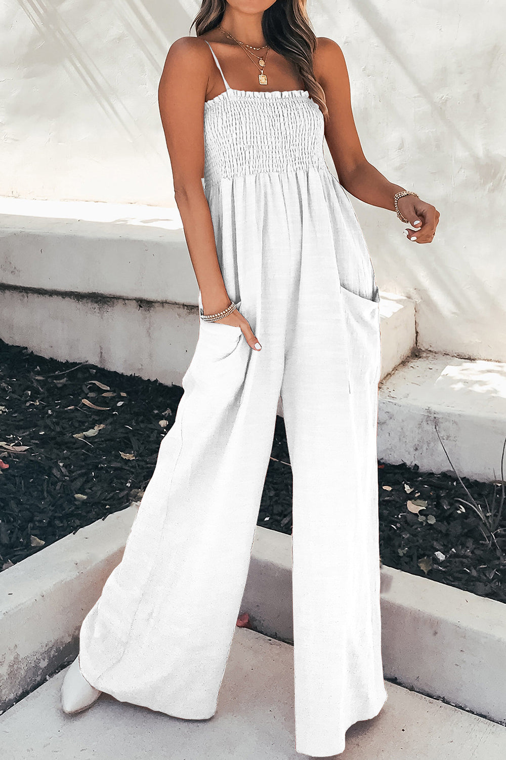 White smocked bodice palazzo jumpsuit with spaghetti straps and wide legs.