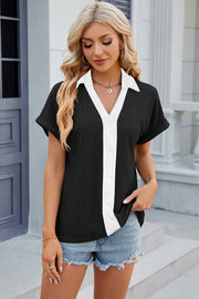 Black perforated polo top with white V-neck detail and short sleeves.