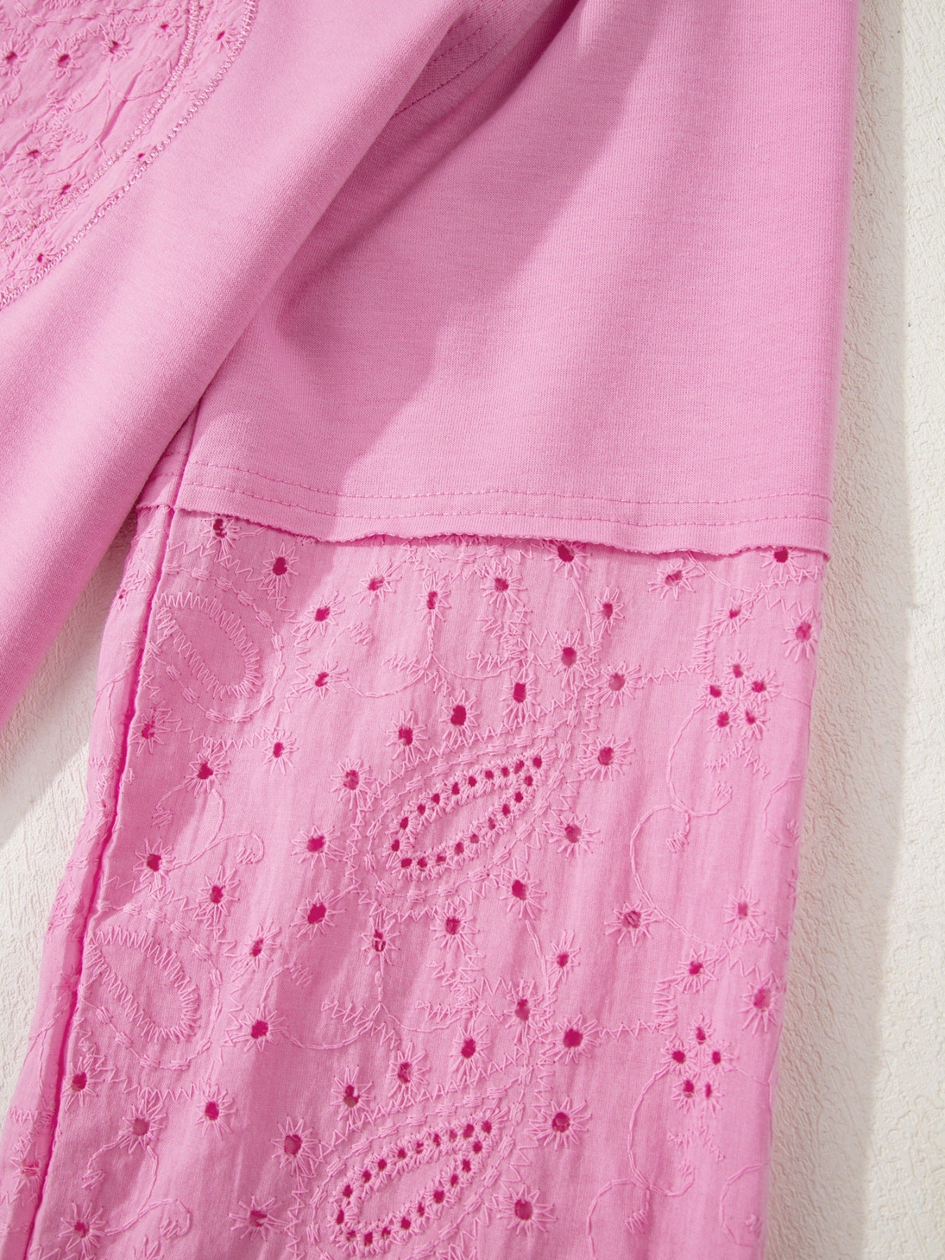 Pink cotton crew-neck sweatshirt with embroidered eyelet detail on the hem.