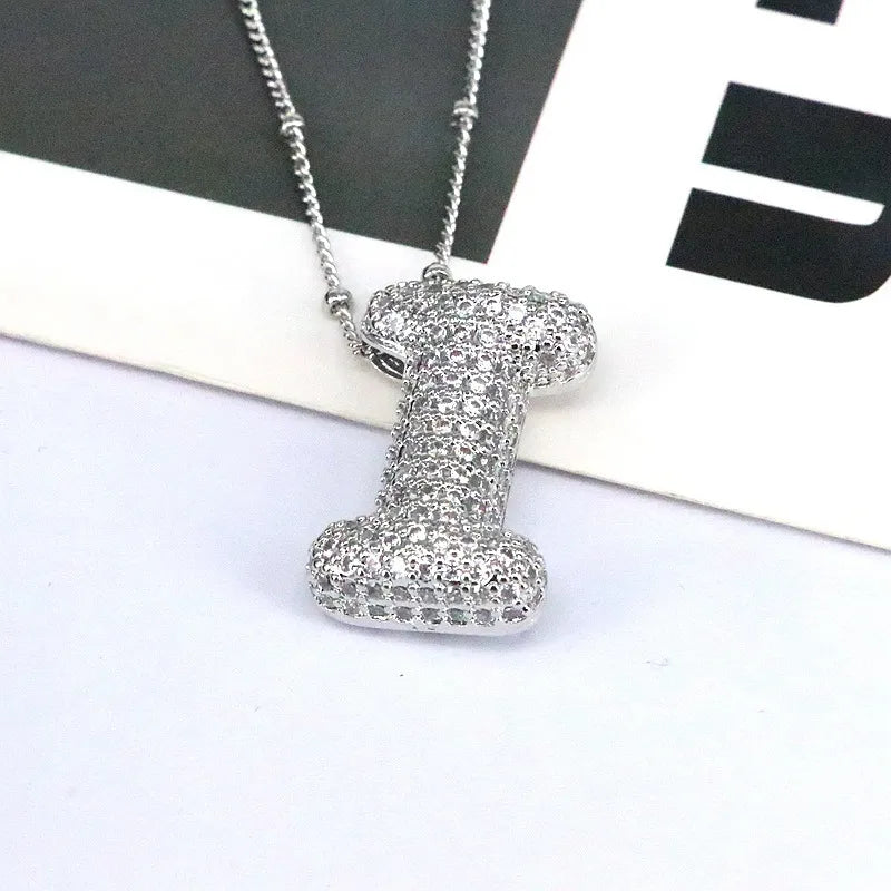 Pave initial bubble pendant necklace with letter I charm in silver tone.