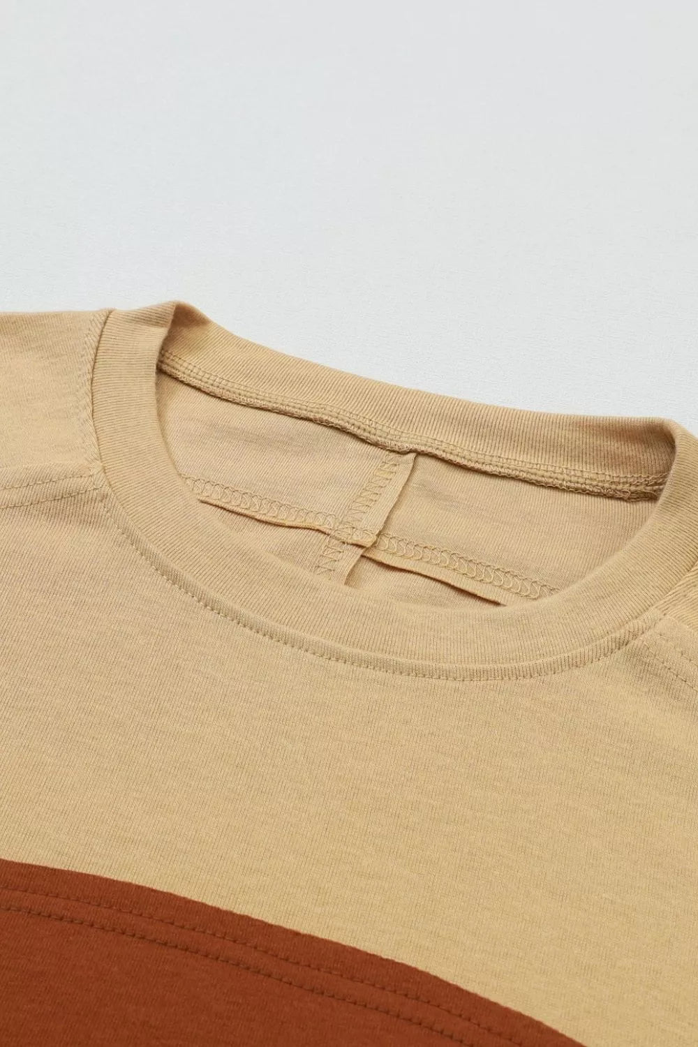 Multi-tonal bishop sleeve shirt in mustard and brown colorblock with crew neck.