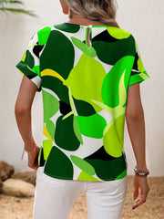 Women's abstract floral print t-shirt in green, white, yellow, and black with short sleeves and a keyhole back detail.