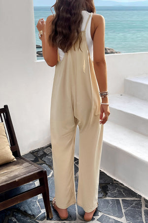 Relaxed drape pocket jumpsuit in light yellow with wide legs and adjustable straps.