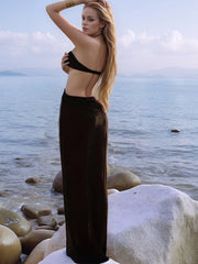 Black cutout maxi dress with a backless halter top and flowing skirt.