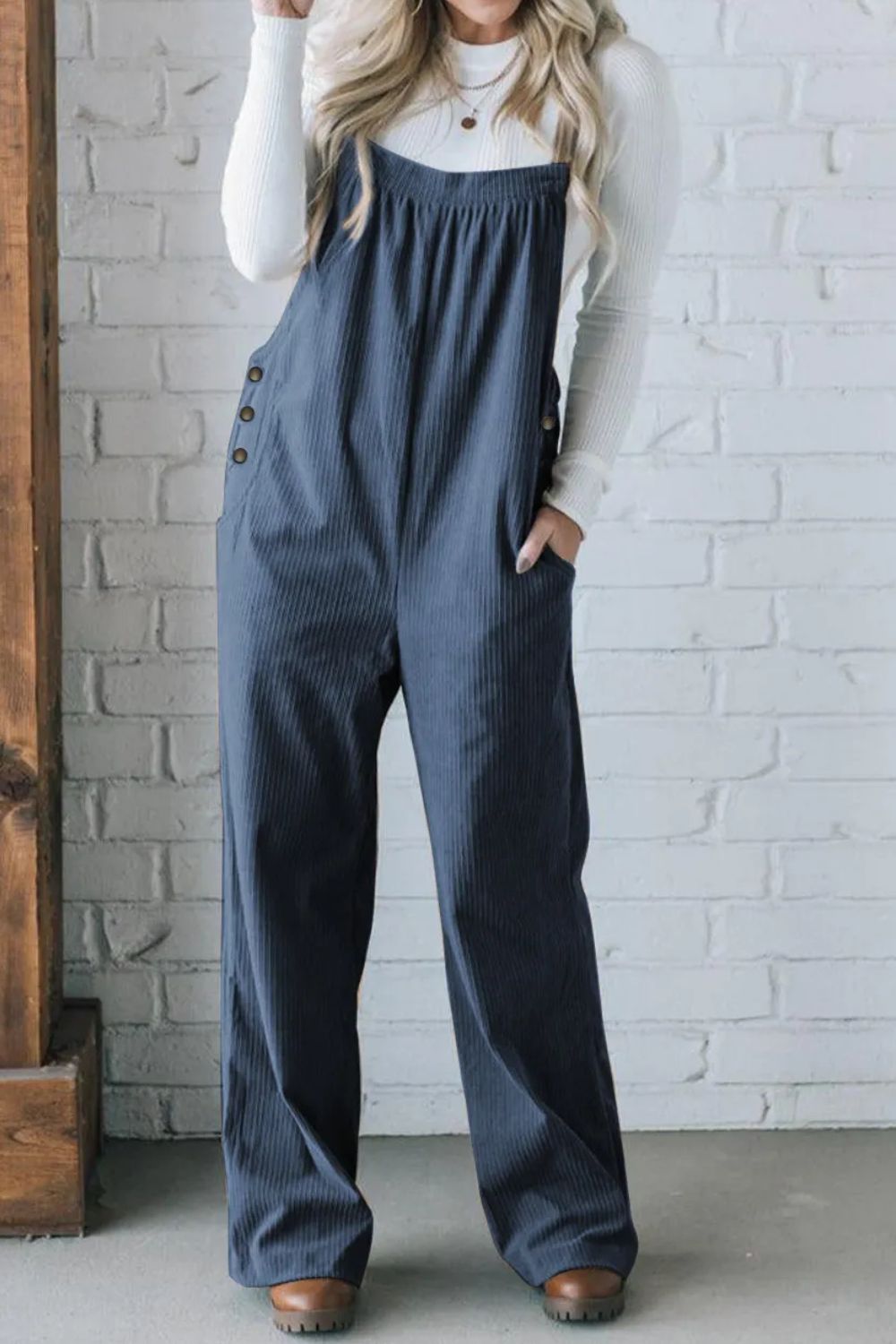 Peacock blue corduroy wide-leg overalls with button details and pockets.