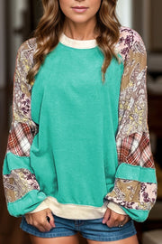 Turquoise patchwork raglan sleeve sweatshirt with paisley and plaid details.