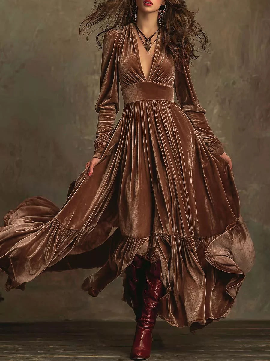 Dark brown velvet maxi dress with voluminous sleeves, deep V-neck, ruffled tiers, and flowing skirt.