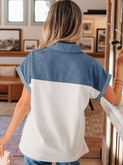 Two-tone denim polo shirt with collar, short sleeves, and color-block detail.