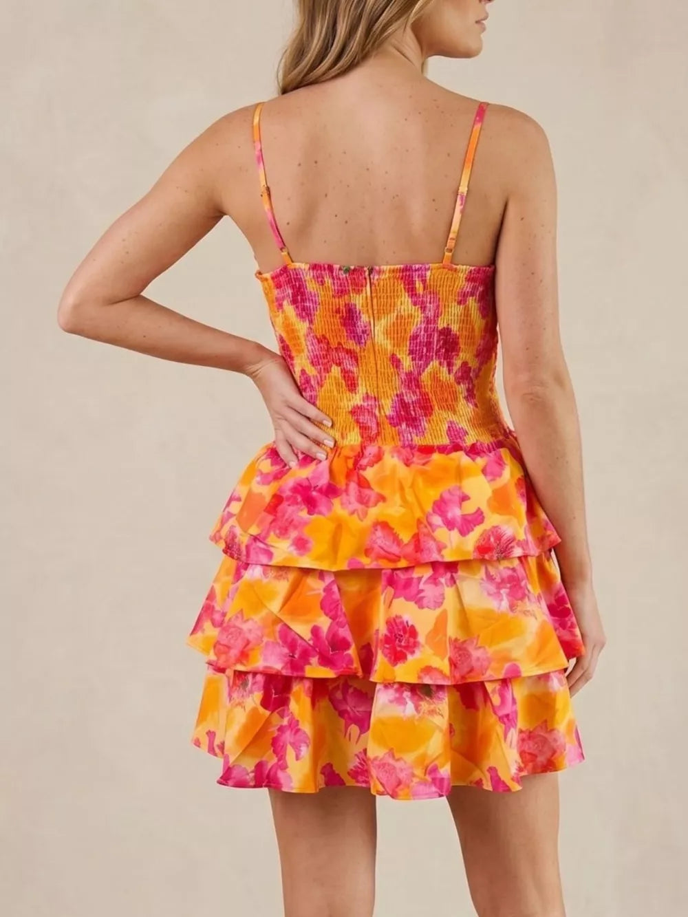 Floral cutout tiered mini dress with smocked bodice and spaghetti straps in orange and pink.