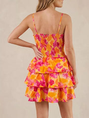 Floral cutout tiered mini dress with smocked bodice and spaghetti straps in orange and pink.