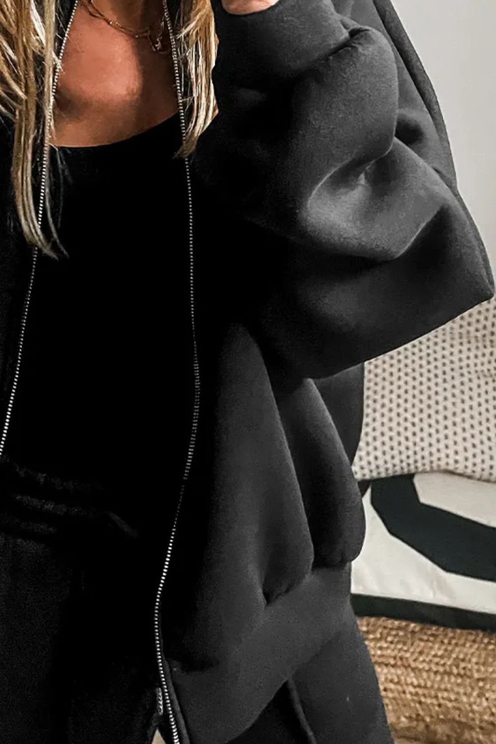 Black zip-up bomber jacket with a relaxed fit and silver zipper detail.
