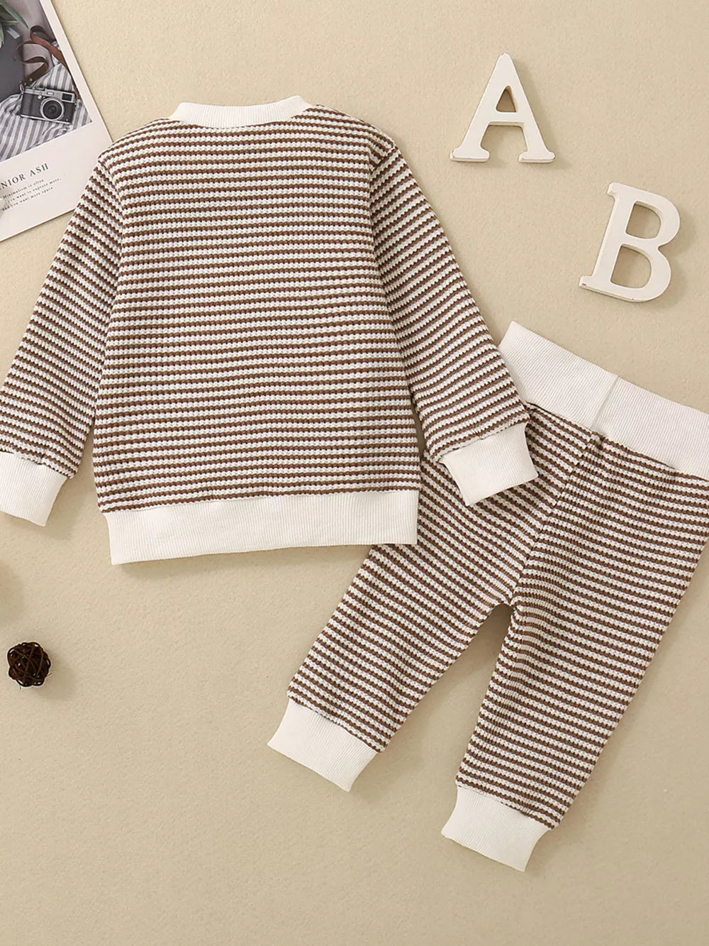 Baby knit set with brown and white stripes, long sleeves, and ribbed cuffs and hem.