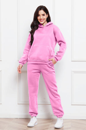 Pink relaxed fit hoodie and joggers set with front pocket and cuffed ankles.