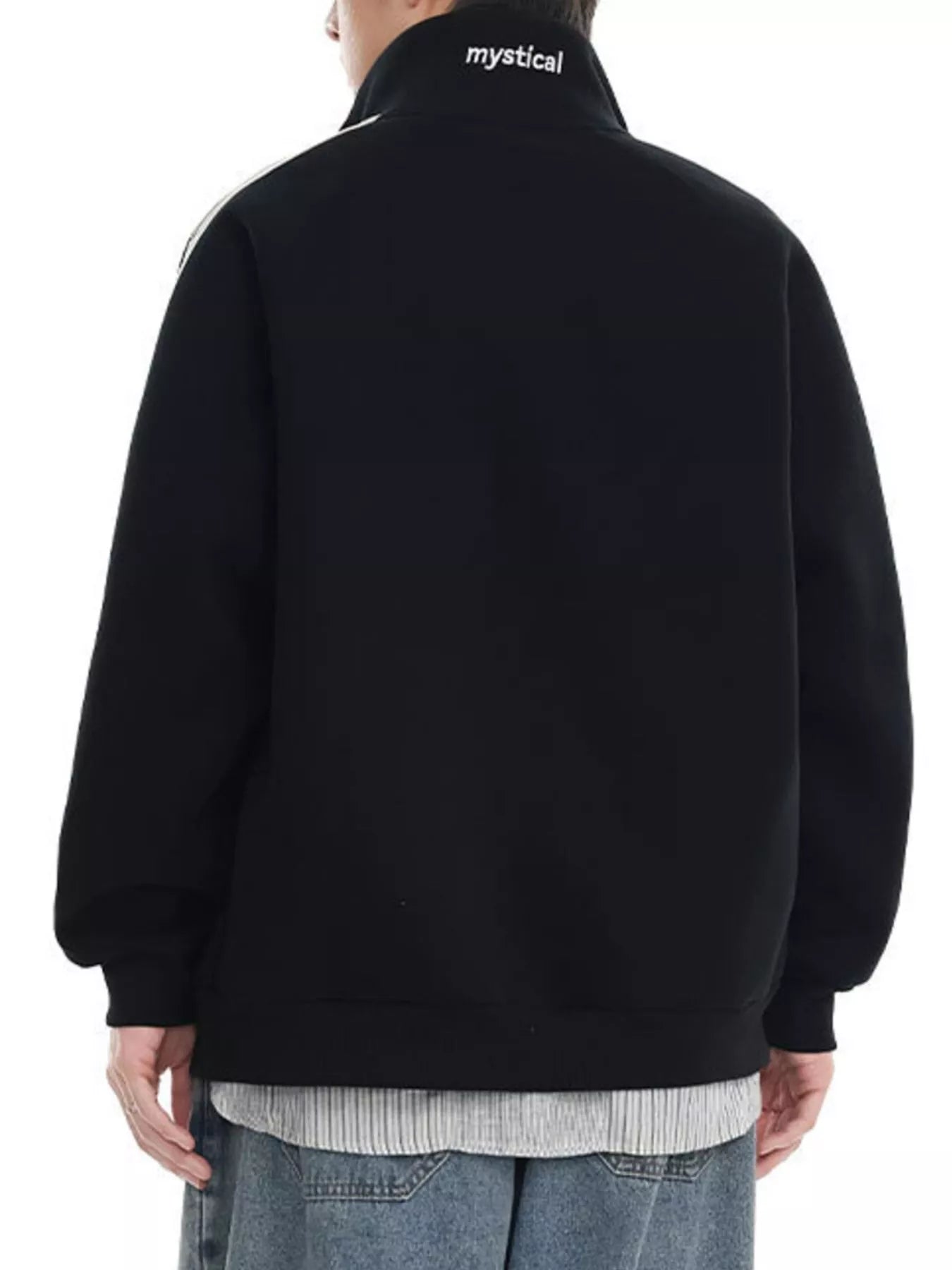 Black zip-up sweatshirt with white stripe detail on shoulder and "mystical" text on collar.
