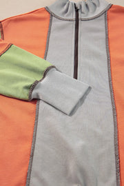 Panelled zip-up sweatshirt in gray, orange, and green with contrast stitching and ribbed cuffs.