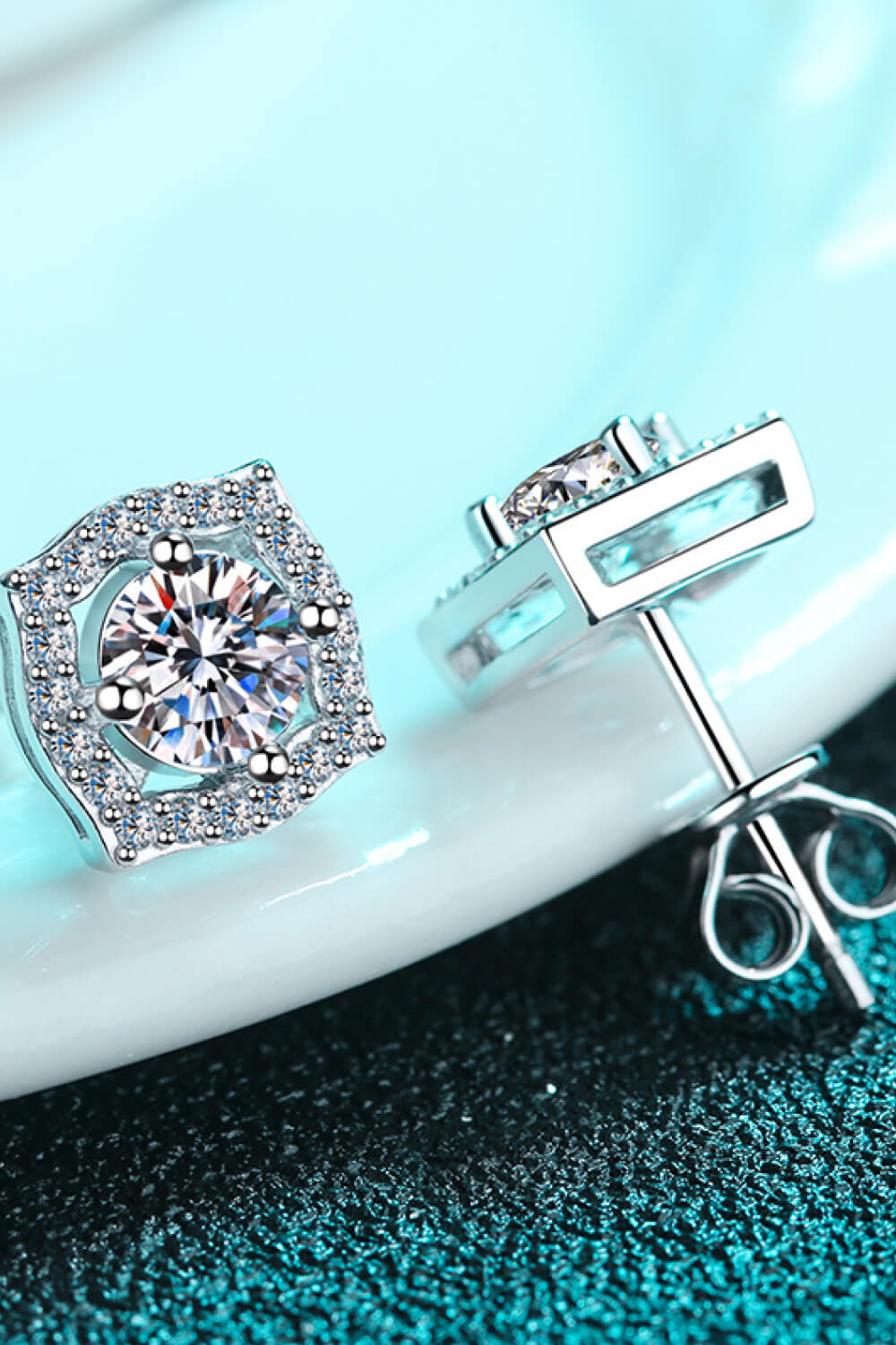 Scalloped halo moissanite stud earrings in silver with a central round diamond and surrounding pave stones.