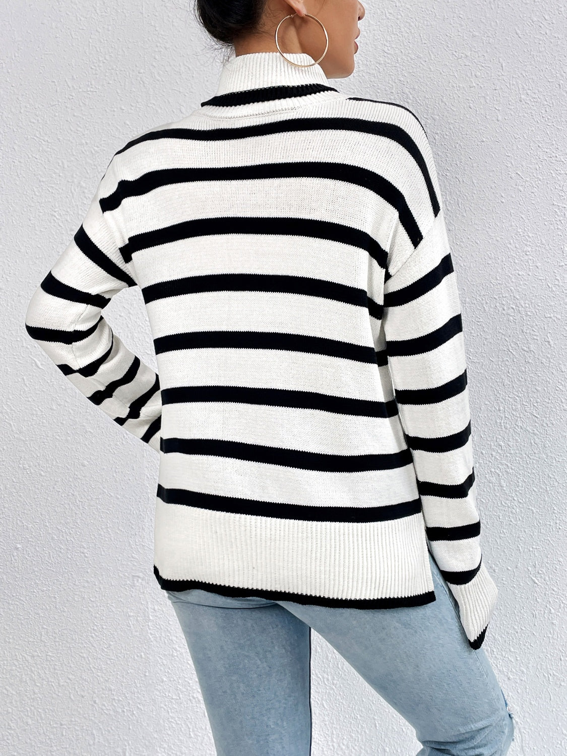 Oversized black and white striped turtleneck sweater with ribbed cuffs and hem.
