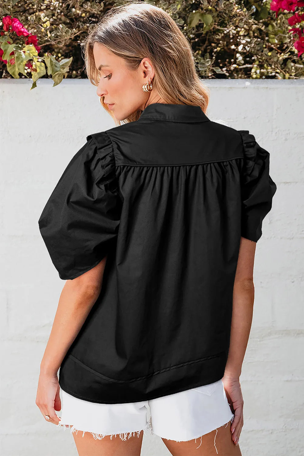 Black poplin blouse with gathered short puff sleeves and button front detail.