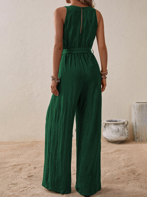 Dark green textured wrap-front wide-leg jumpsuit with belted waist and sleeveless design.