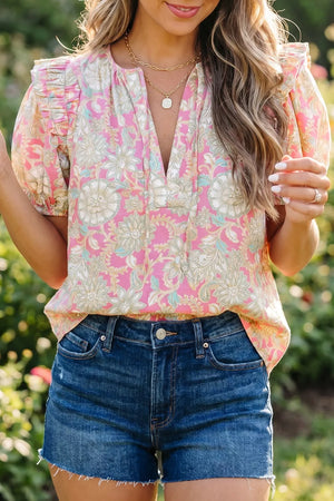 Ruffled floral print v-neck shirt in pink polyester with short sleeves and a gathered neckline.